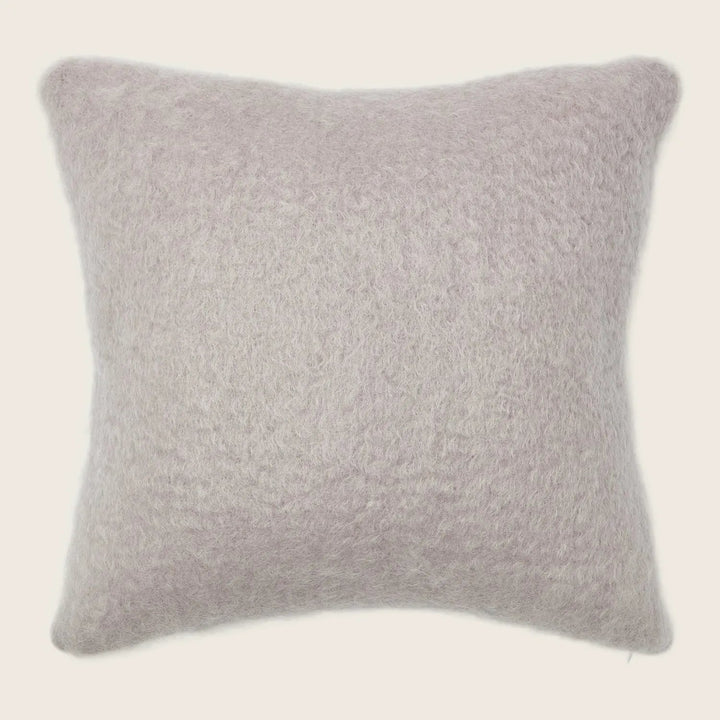 Cozy and versatile, this fluffy taupe pillow adds comfort to any space.