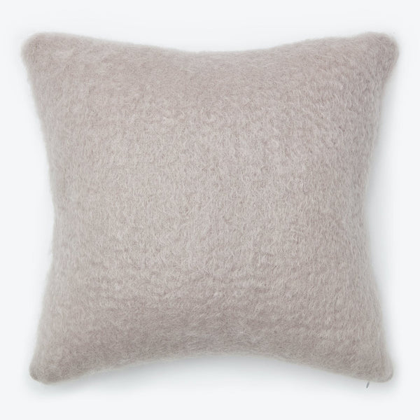 Cozy and versatile, this fluffy taupe pillow adds comfort to any space.