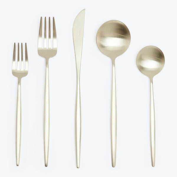 A set of four elegant gold cutlery pieces on white.