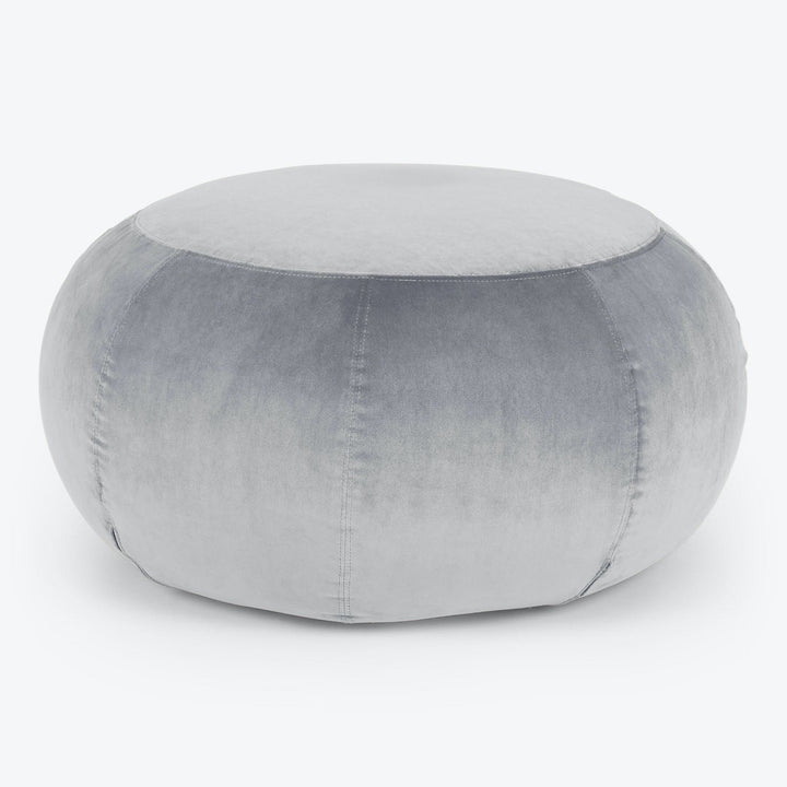 Plush grey velvet pouf with stitched seams on white background.