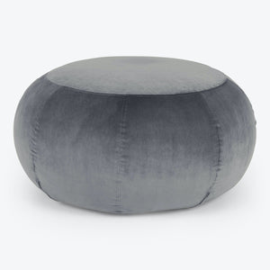 Round, blush-pink pouf with plush velvet texture and stitched segments. - hover