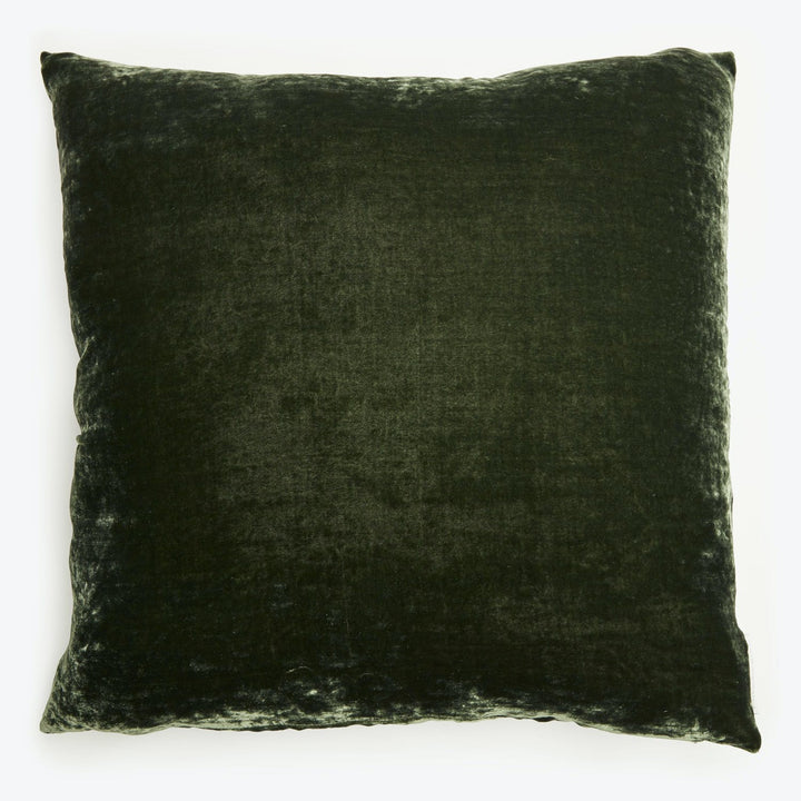 Square plush cushion with velvet-like texture in dark color.
