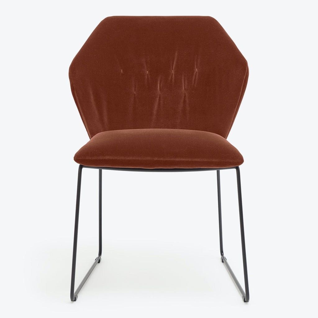 Minimalist modern chair with velvet upholstery and sleek metal legs.
