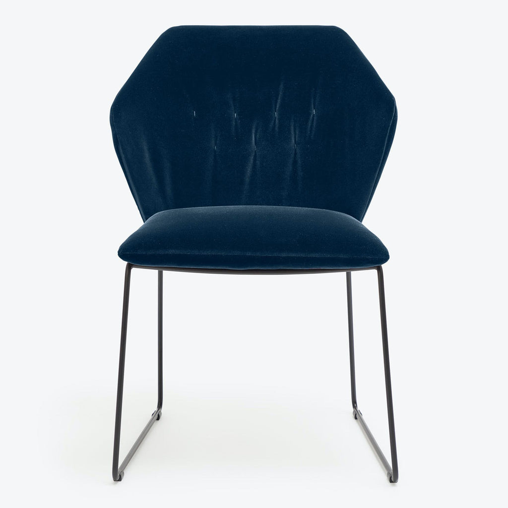 Contemporary chair with wing-like backrest and plush dark blue velvet upholstery.