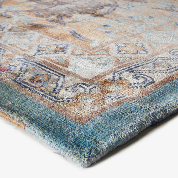 Close-up of vintage-inspired area rug with cream, blue, and brown tones.