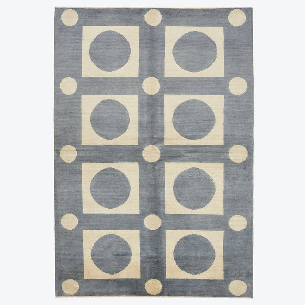 Rectangular grey rug with modern geometric pattern in beige and cream.