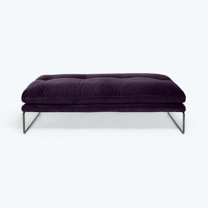 Plush purple ottoman with sleek metal frame exudes modern luxury.