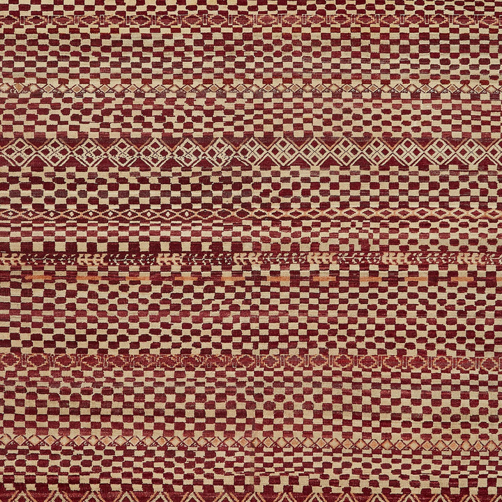Close-up of a complex geometric textile pattern in red and beige.