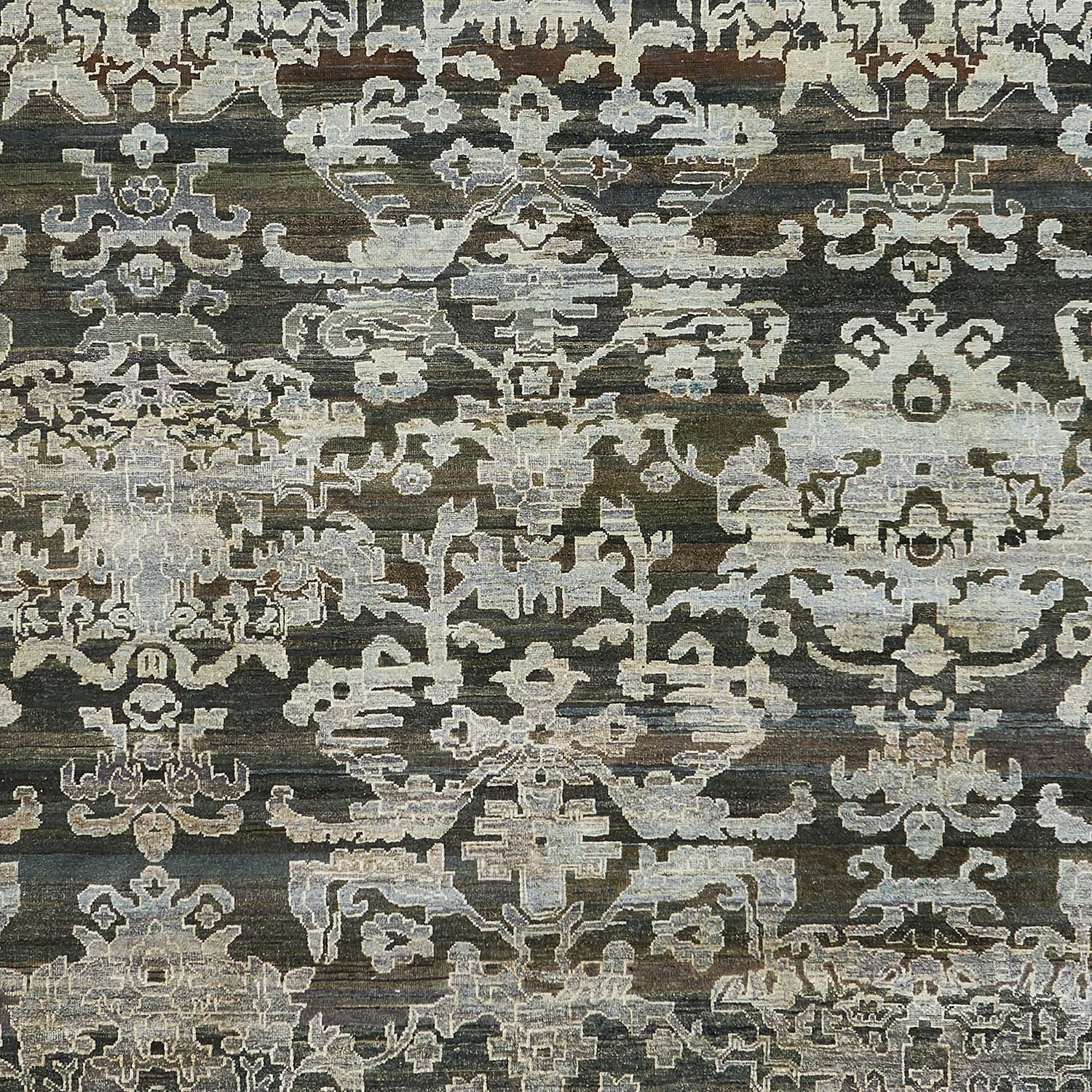Intricate symmetrical motifs in vintage, faded hues on traditional carpet.