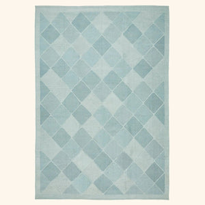 Contemporary diamond-patterned rug in shades of blue creates a calming atmosphere.