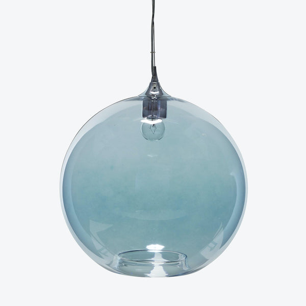 Globe-shaped pendant light with transparent blue tint illuminates modern space.