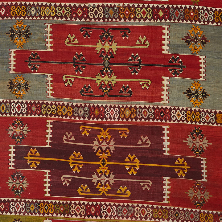 Vibrant hand-woven rug showcases intricate symmetrical patterns in rich colors.