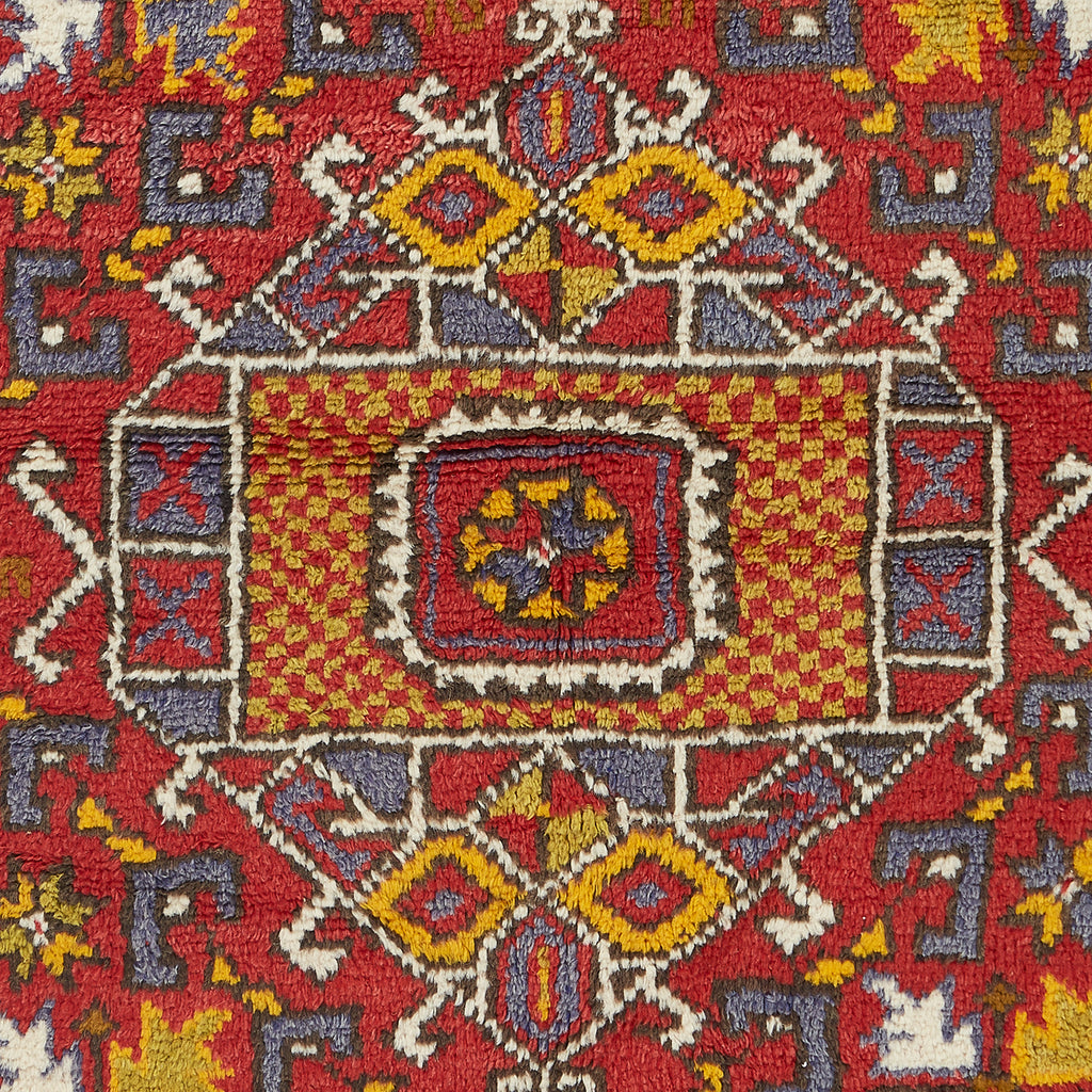 Vibrant, symmetrical carpet displays intricate geometric patterns in rich colors.