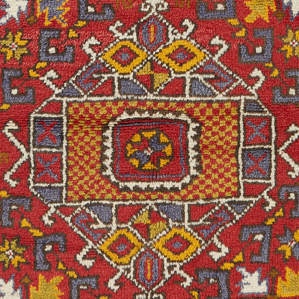 Vibrant, symmetrical carpet displays intricate geometric patterns in rich colors.