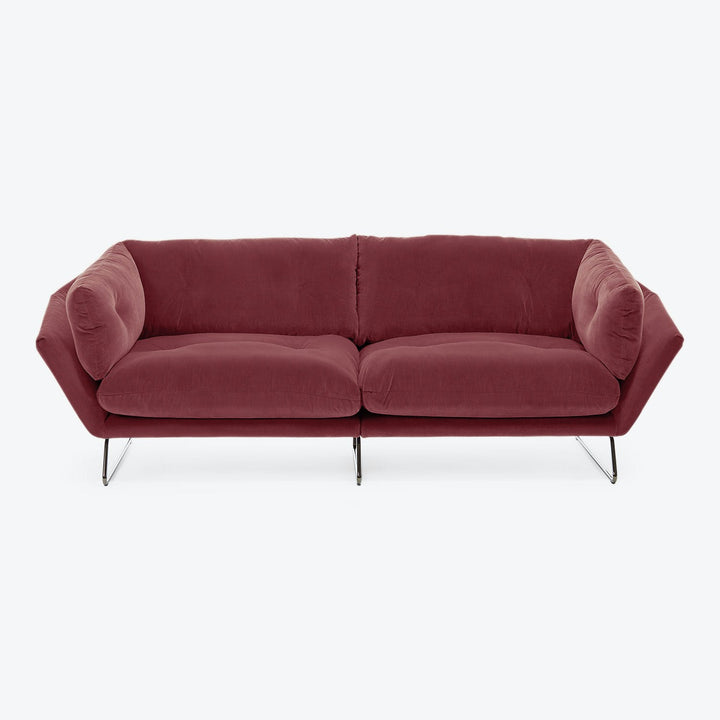 Modern red sofa with streamlined design, chrome legs, luxurious upholstery.