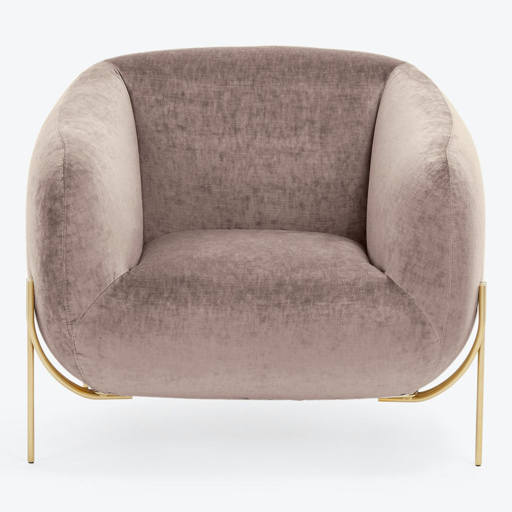 Modern-style armchair with a plush, blush velvety upholstery and sleek metallic legs.