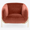 Modern armchair with curved silhouette and plush dusty rose upholstery.