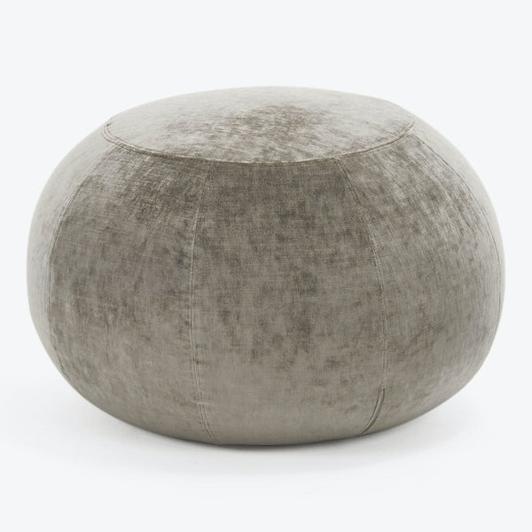 Neutral gray upholstered pouf with distressed texture and visible stitching.