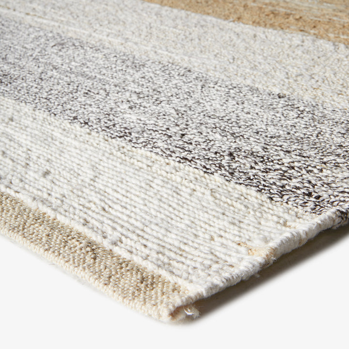 A close-up of a gradient rug showcasing varied textures and wear.