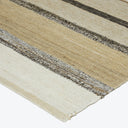 Neutral-toned striped rug with rough and frayed edges for casual style.