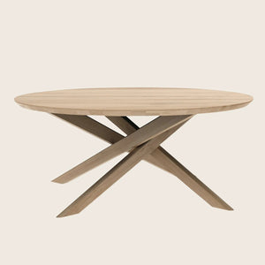 Modern wooden table with a round natural top and X-shaped base.