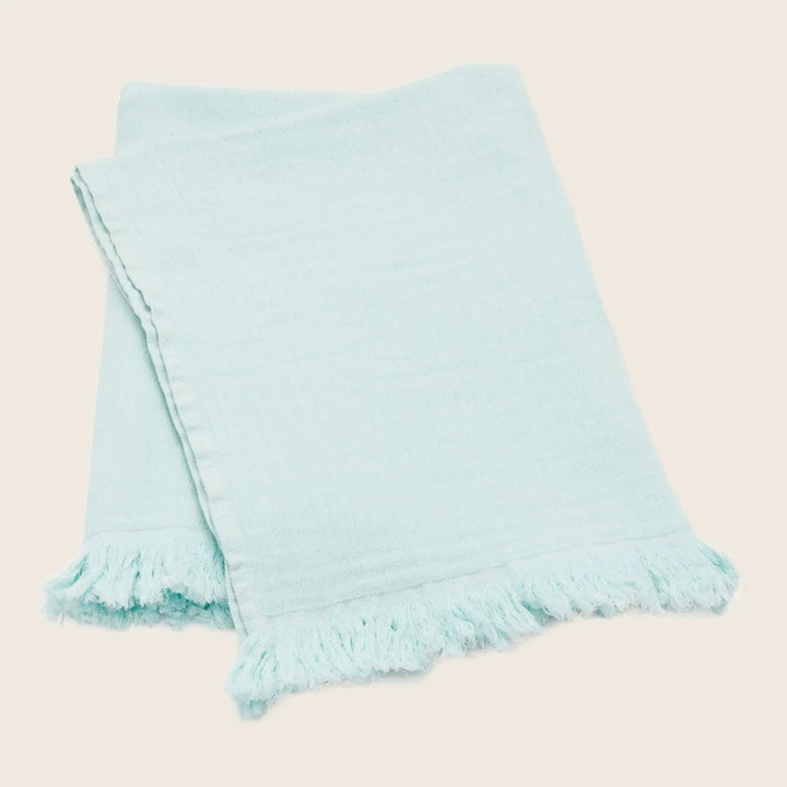 Light blue textile with fringe detail, adding casual decorative touch.