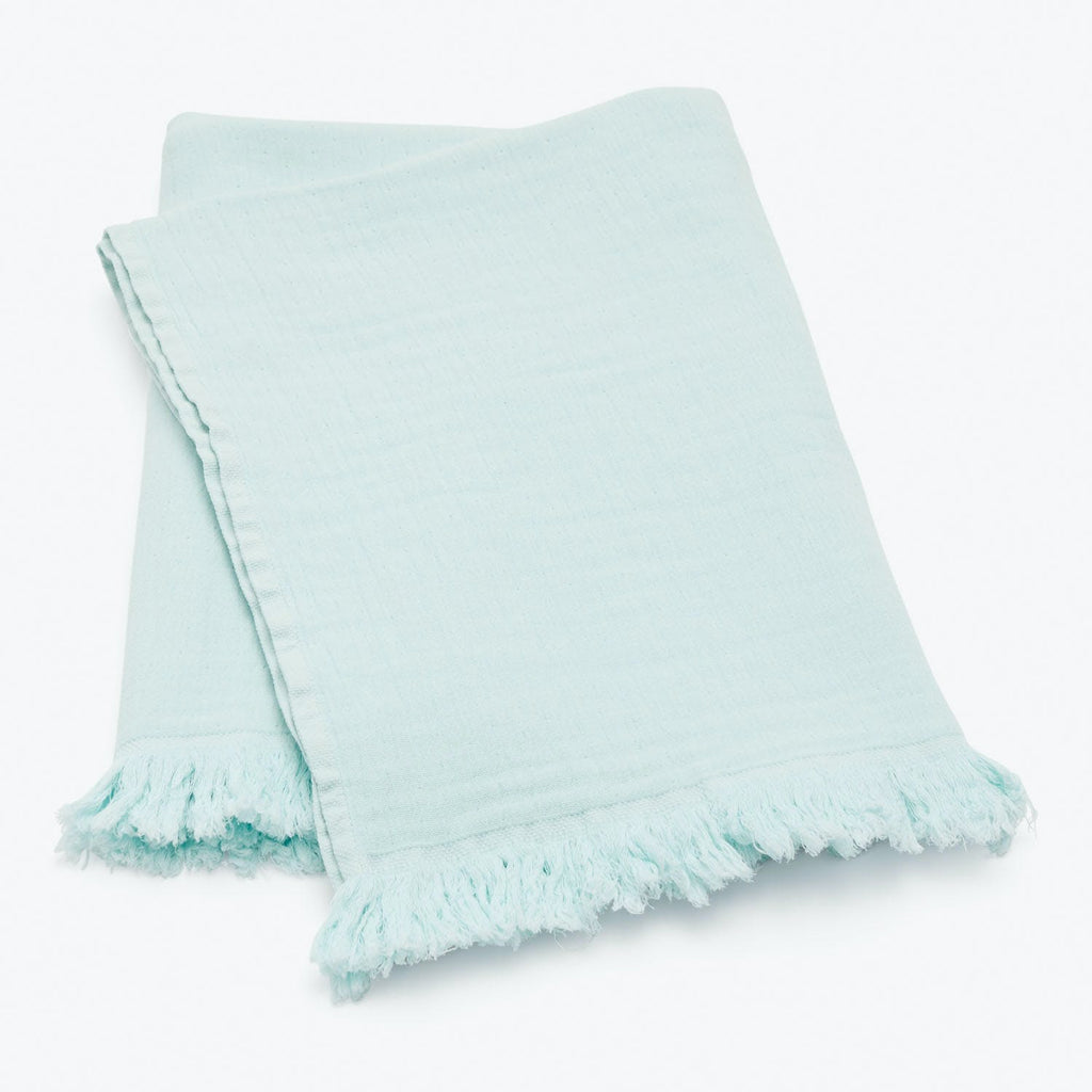 Light blue textile with fringe detail, adding casual decorative touch.