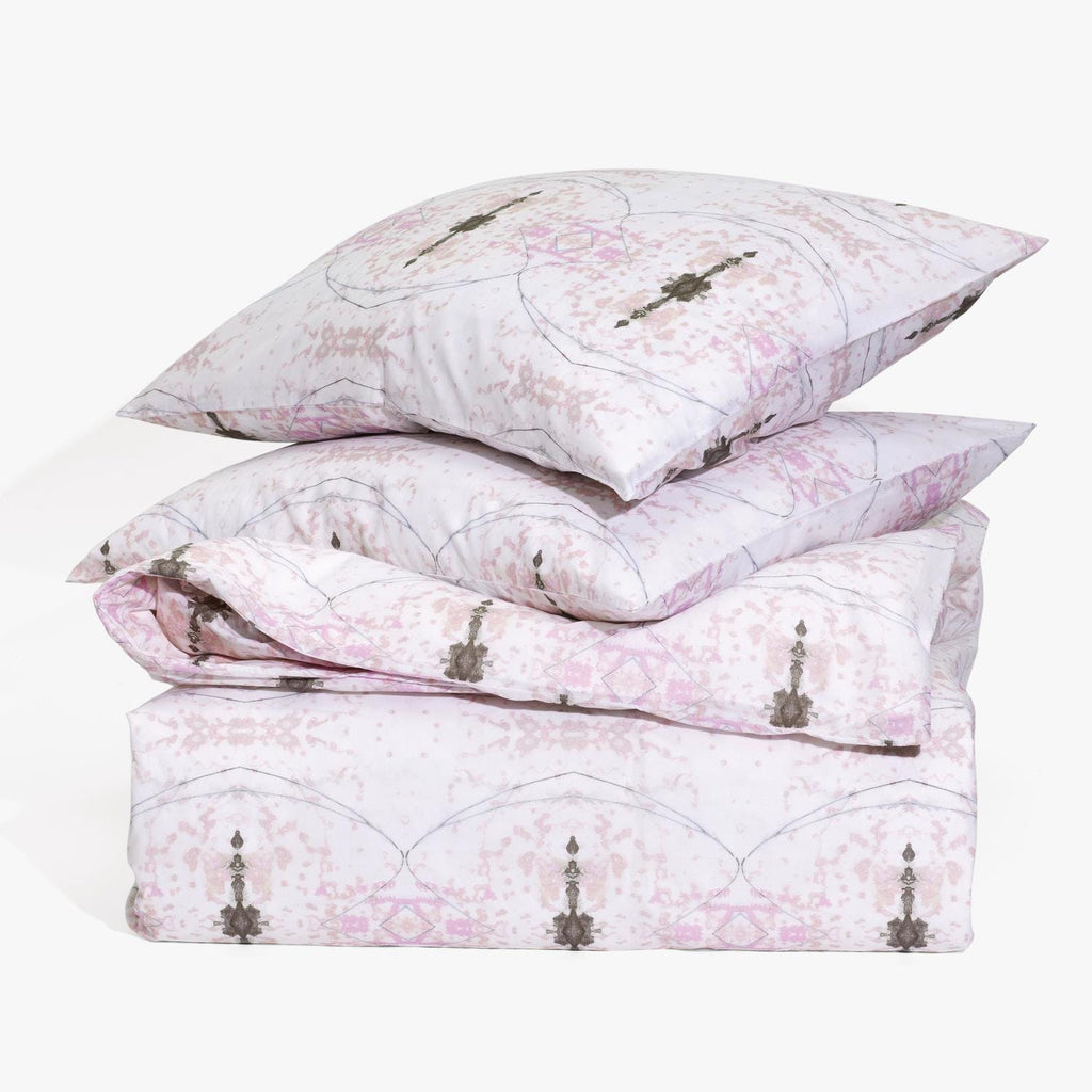 Elegantly folded bedding set with pink and purple decorative pattern.