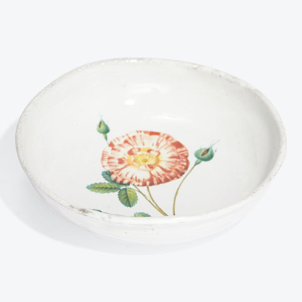 Artisanal ceramic bowl with floral motif showcases rustic charm.