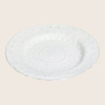 Ornate white ceramic plate with embossed floral design and scalloped edge