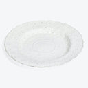 Ornate white ceramic plate with embossed floral design and scalloped edge