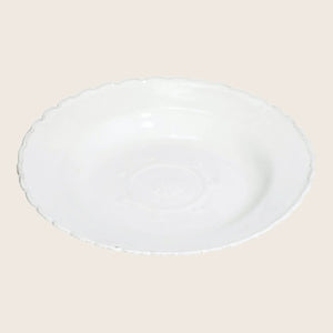 White ceramic plate with scalloped edge and embossed floral pattern.