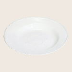 White ceramic plate with scalloped edge and embossed floral pattern.