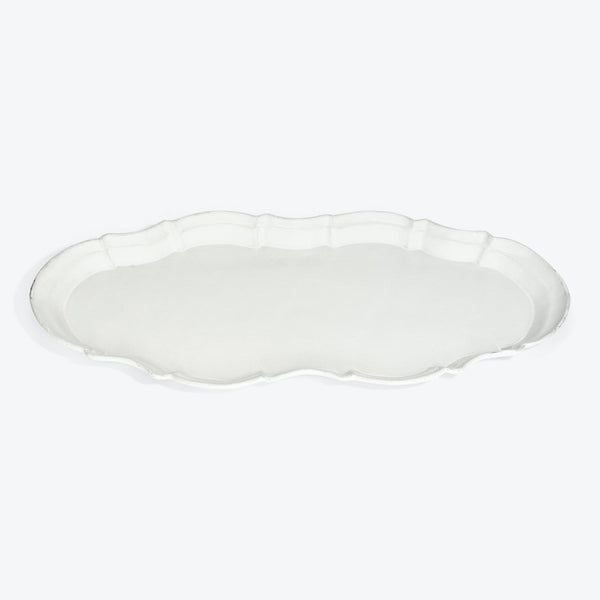 Simple and elegant white ceramic platter with scalloped edges.