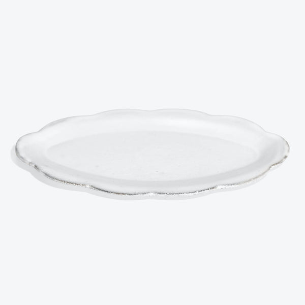 Versatile round white ceramic plate with a sleek scalloped edge.