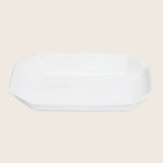 An elegant white octagonal platter with raised edges for serving.