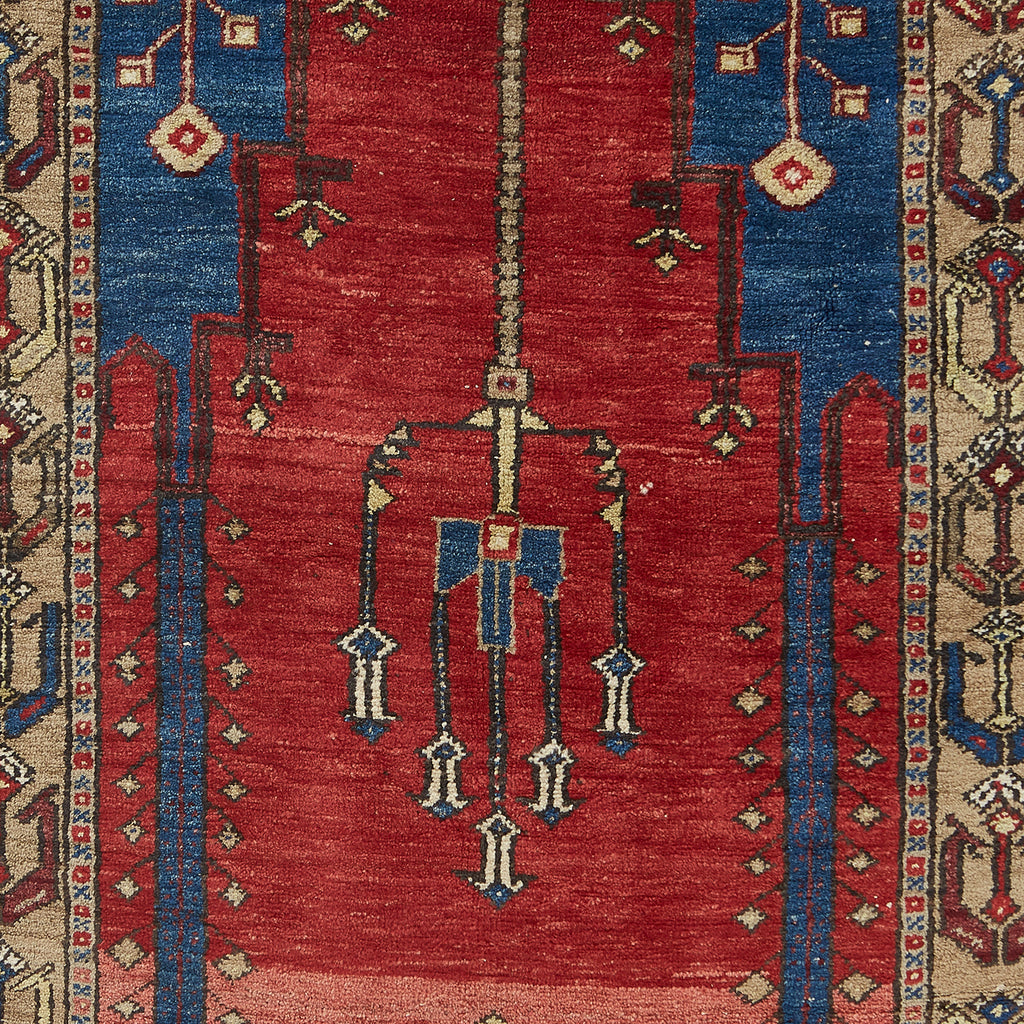 Traditional handwoven rug with red background and geometric motifs.