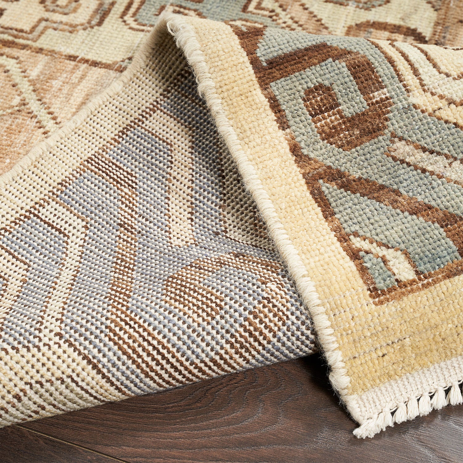 Close-up of patterned area rug flipped to reveal underside.