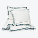 Neatly arranged bedding set with white base and blue-grey stripes.