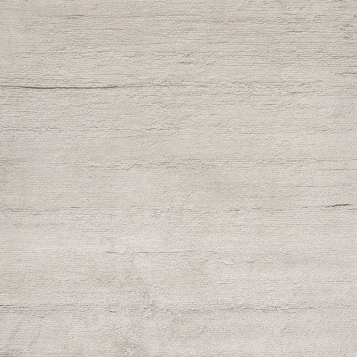 Neutral textured surface resembling a pale concrete wall with horizontal lines.