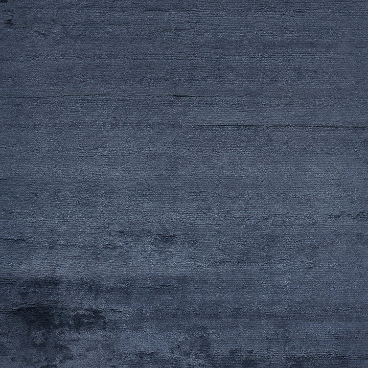 Textured surface with dark color resembling fabric or painted wall.