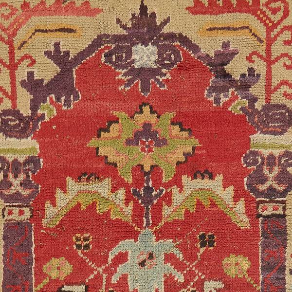 Close-up of an intricate, aged textile featuring symmetrical floral design