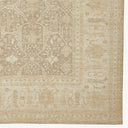 Subtle, faded rug with intricate arabesque motifs in muted tones.