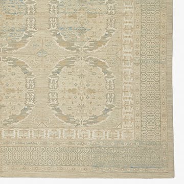 Exquisite vintage rug showcases symmetrical patterns and delicate floral motifs.