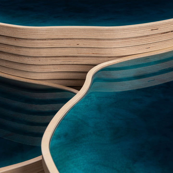Close-up view of multi-layered wooden structure with sinuous form.