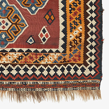 Intricate, symmetrical rug showcases traditional weaving style with vibrant colors.