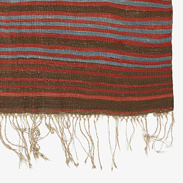 Colorful fringed textile with rustic stripes adds warmth and texture.