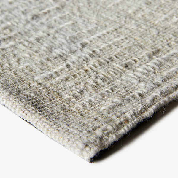 Close-up of durable textured carpet with speckled gray patterns.