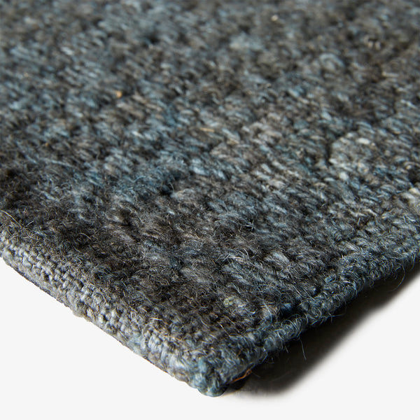 Close-up of a gray, textured fabric with visible weave and pile.