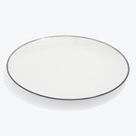 Round white plate with a thin black rim and glossy finish.